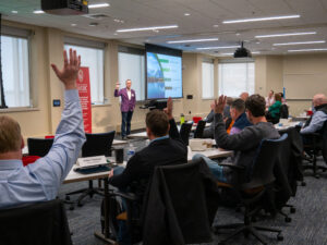 people raising hands at a peer group meeting