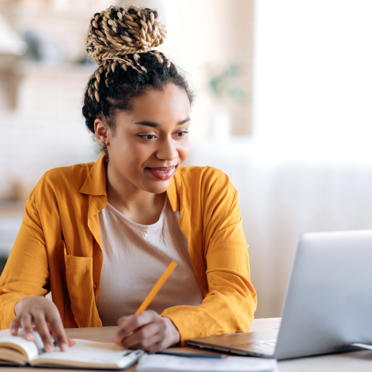 woman taking notes at laptop